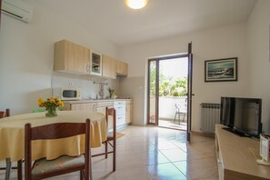 Appartement, 2 slaapkamers | Privékitchenette | Een koelkast, een magnetron, een kookplaat, kookgerei, borden en bestek