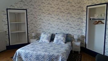 Un dormitorio con cama, mesitas de noche, armario y closet.
