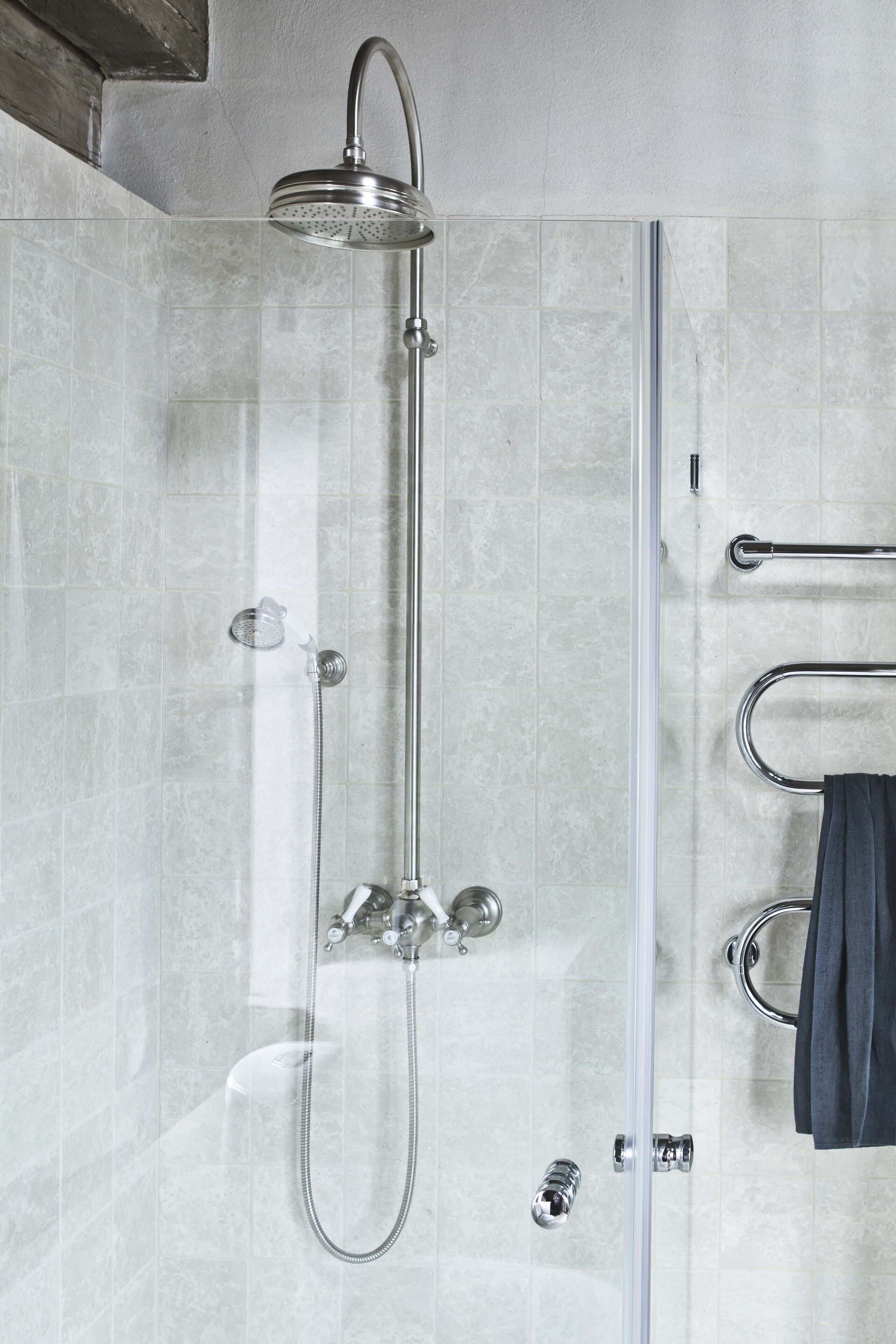A shower with a handheld showerhead, a handheld showerhead, a handheld showerhead, a handheld showerhead, and a handheld showerhead.