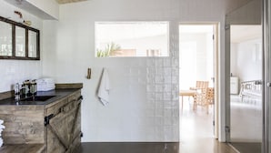 A modern kitchen with a wooden countertop, a built-in sink, and a window above the sink. - Siggesta Gård (Värmdö)