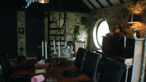 Ein Essbereich mit Steinwand, Kamin und Fenster.