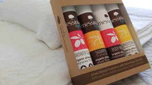A box of Messinian Spa products on a bed with a white towel. - Papillon (Astypalaia)