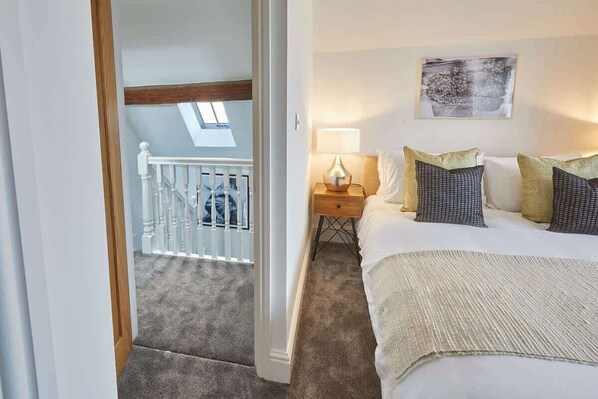 A bedroom with a bed, nightstand, lamp, and artwork on the wall. - Host & Stay | Caedmon House (Whitby)