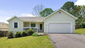 A single-story house with a front porch, a garage, and a well-maintained lawn.