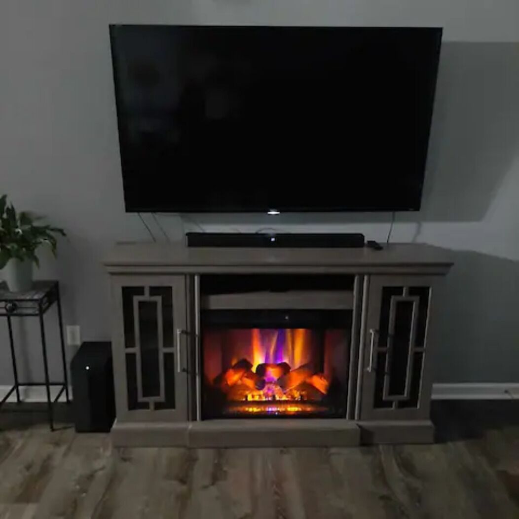 A living room with a flat-screen TV mounted above a fireplace.