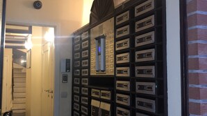 A hallway with a mail drop box system, a stairwell, and a door leading to another room. - Residence la Fraisiere (Brussels)