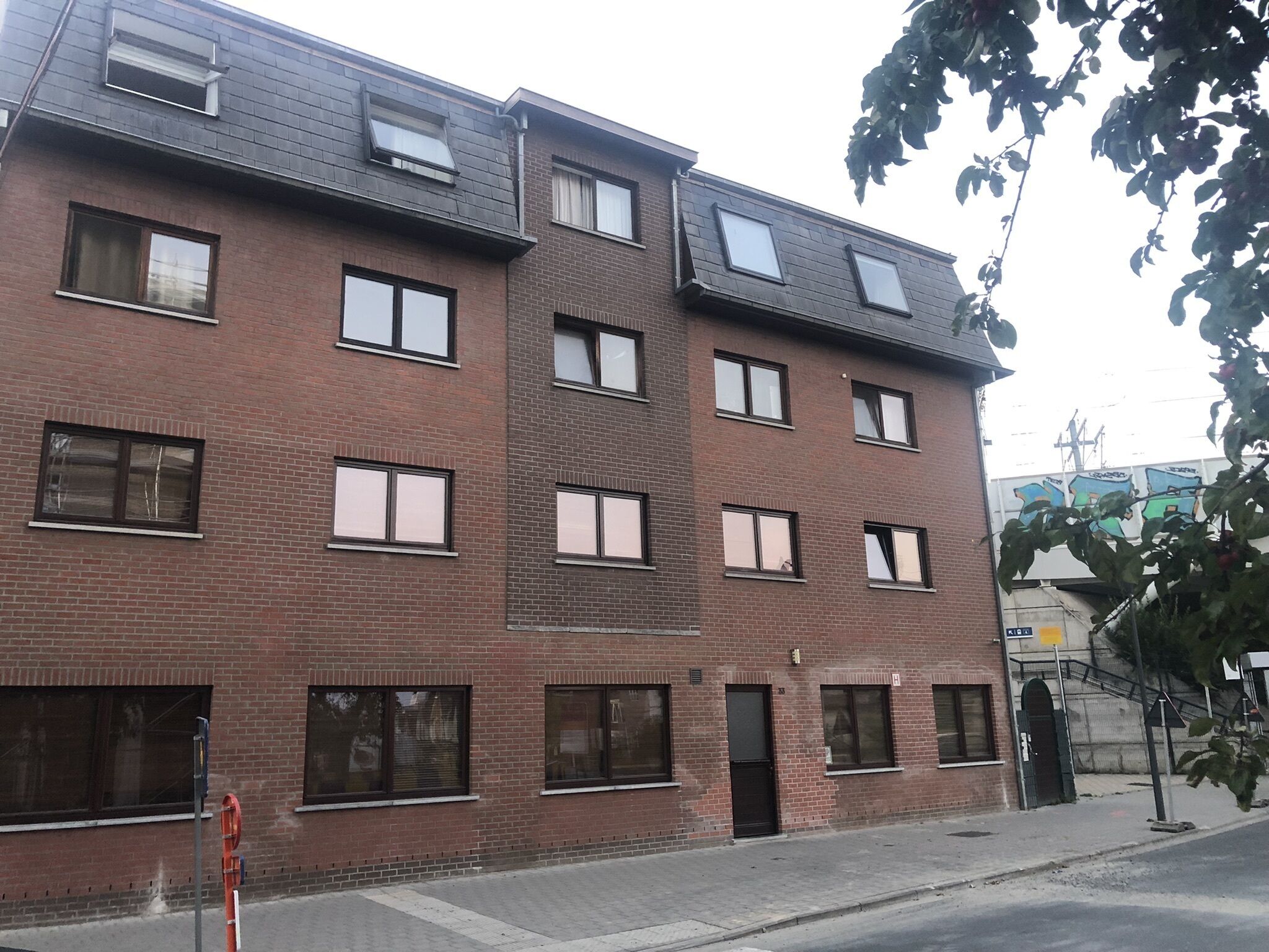 A multi-story brick building with multiple windows and a flat roof.