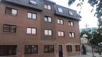 A multi-story brick building with multiple windows and a flat roof.