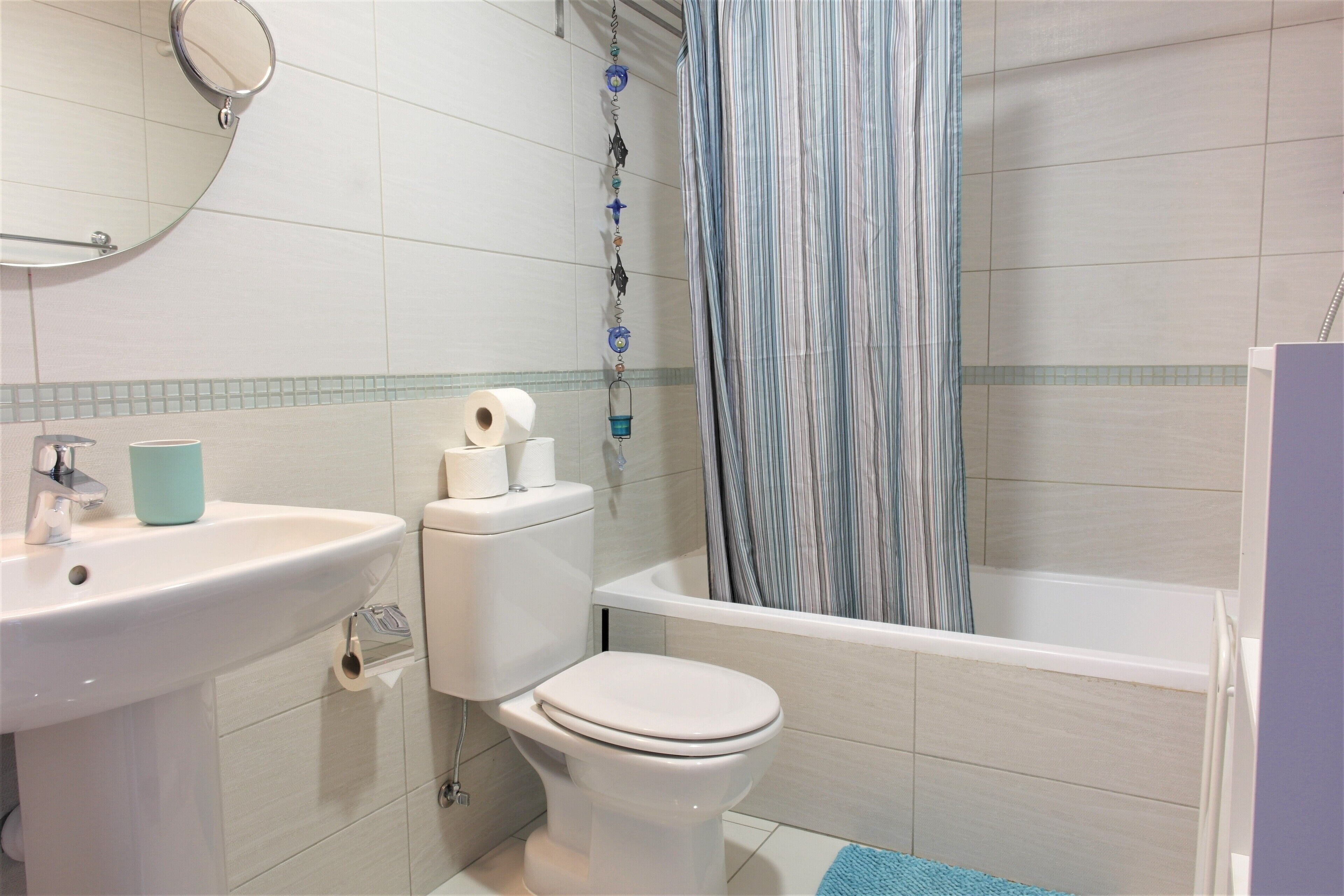 Un baño con lavamanos, inodoro y bañera.