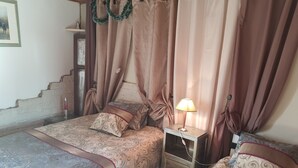 Une chambre avec deux lits, une table de chevet et une lampe.