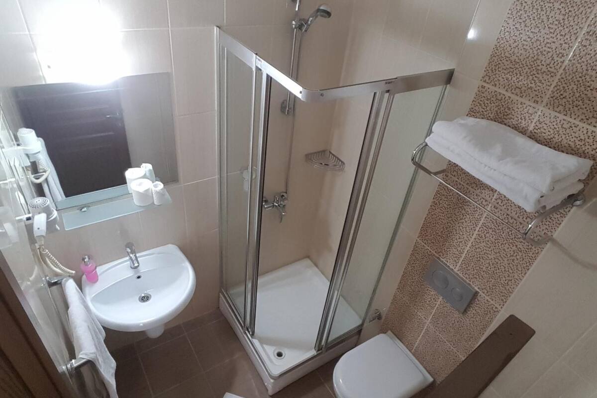 shower, hair dryer, slippers, towels