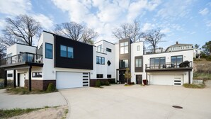 Una zona residencial moderna con varias casas de dos pisos, cada una con garaje y balcón.