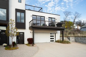 Ein modernes, zweistöckiges Haus mit Balkon, Garage und gepflegtem Garten.