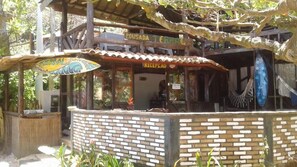 A rustic building with a reception area, a sign reading "POUSADA TERRACE," and a hammock hanging from the ceiling. - Pousada Terral Surf (Itacaré)