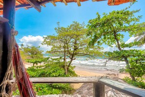 A wooden structure with a view of a beach and ocean. - Pousada Terral Surf (Itacaré)
