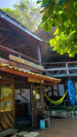 A rustic building with a sign reading "POUSADA TERRAS" and "RECEPCAO". - Pousada Terral Surf (Itacaré)