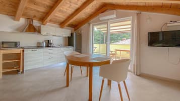 Appartement (Viviana A2 Ana) | Privékeuken | Een koelkast, een kookplaat, kookgerei, borden en bestek