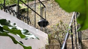 Una escalera de piedra con barandilla de metal que conduce a un muro de ladrillo.