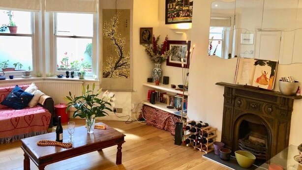Una sala de estar con chimenea, un sofá, una mesa de centro y una estantería.