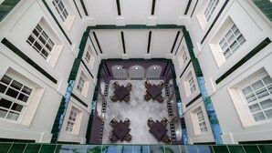A high-ceiling atrium with a central seating area and multiple windows. - Hotel Platería by Bossh Hotels (Ecija)