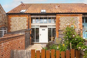 A two-story house with a tiled roof, a brick exterior, and a front door labeled "Off-Owner." - Cog Cottage, Great Walsingham. Norfolk (Great Walsingham)