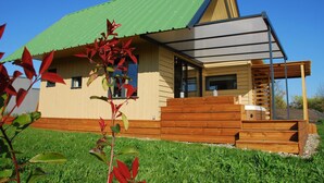 A modern house with a green roof, wooden deck, and a small porch. - Chambre d'hotes Saga (Savignac-Mona)