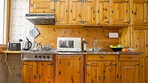 A kitchen with wooden cabinets, a microwave, a stove, and various kitchen utensils. - Tremosine Wonderful Lake View 2, Tremosine, Italy (Tremosine)