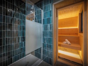 Un sauna avec un banc en bois et une paroi en verre.