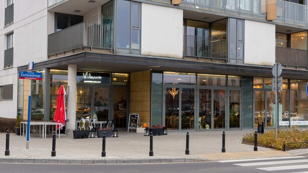 Ein modernes Gebäude mit einem Restaurant namens "Vilano" im Erdgeschoss.