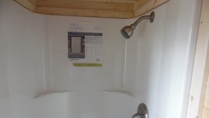 Puerta blanca con panel de control de ducha y cabezal de ducha.