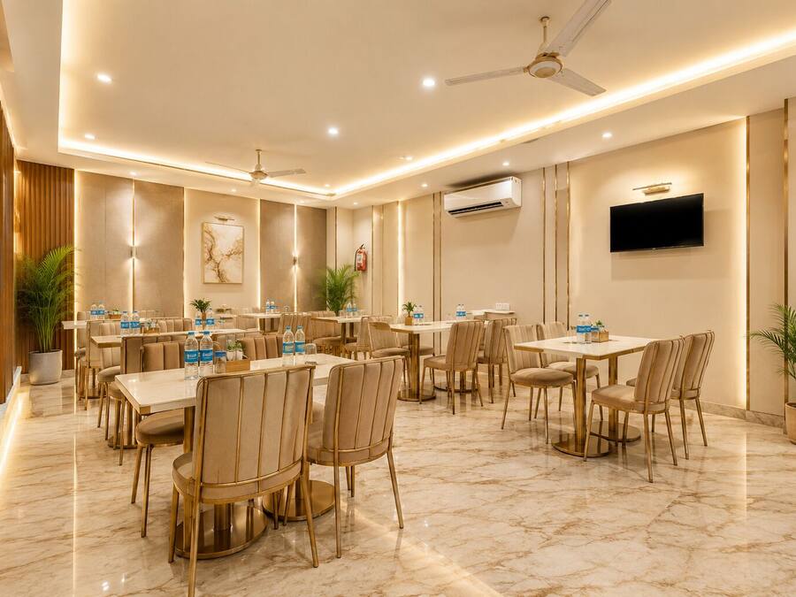 Un comedor de hotel con varias mesas y sillas, ventiladores de techo y un equipo de aire acondicionado.