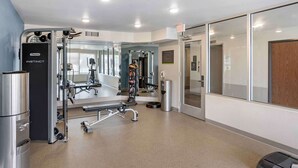 Ein modernes Fitnessstudio mit verschiedenen Trainingsgeräten, darunter eine Gewichtbank und Cardiogeräte.
