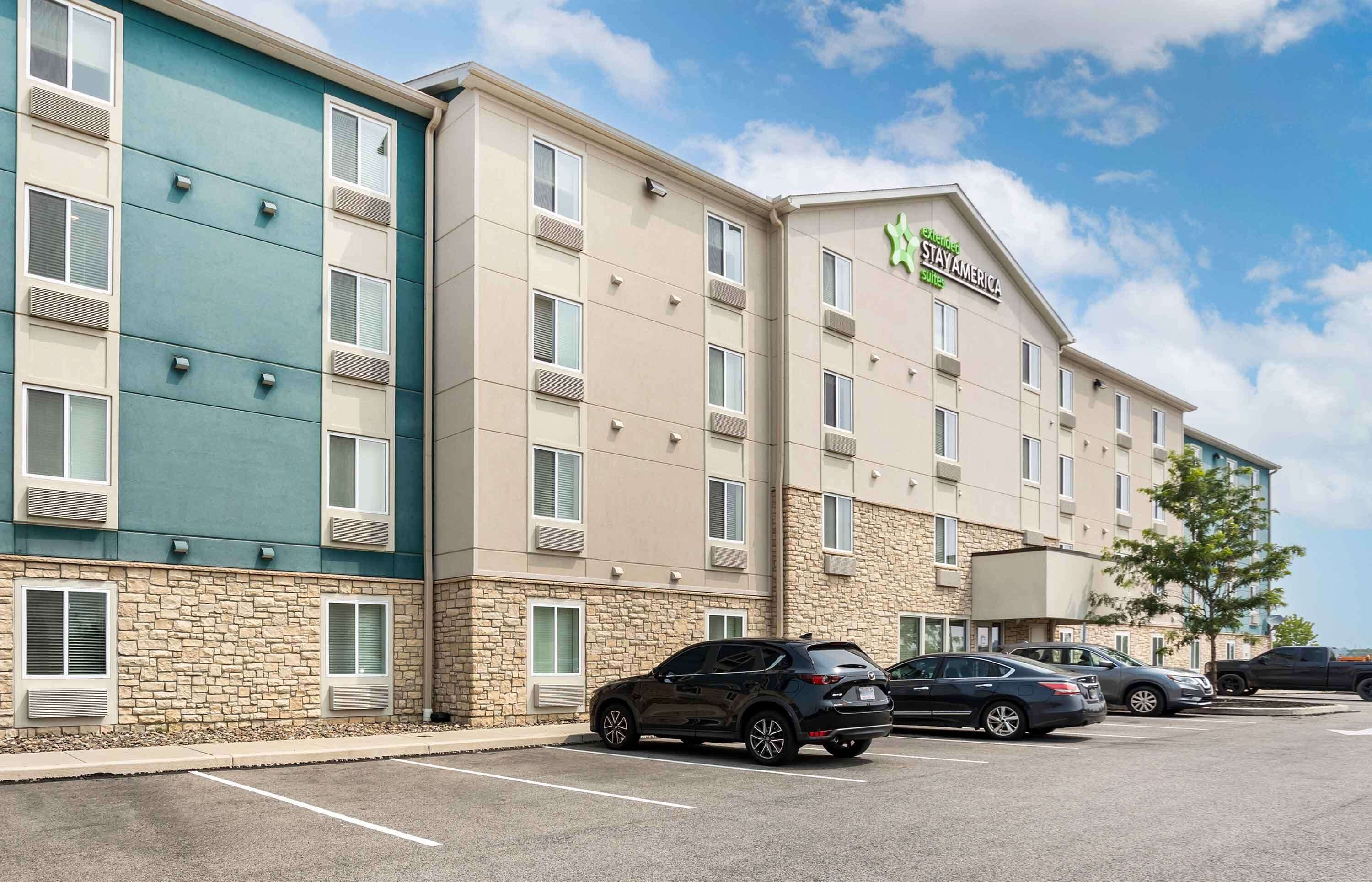 A multi-story hotel with a stone facade and a green and beige color scheme.