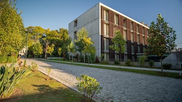 Um edifício moderno com telhado plano, janelas amplas e um pátio pavimentado.