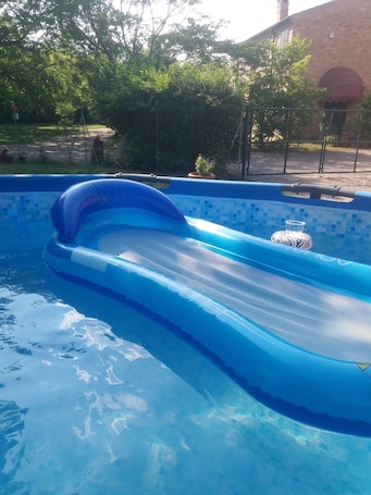 Una piscina al aire libre de temporada, sombrillas