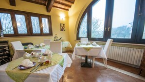 A dining area with tables set for four, equipped with tea sets and white tablecloths. - B&B Un mondo a Colori (Ferrara)