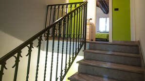 A staircase with a wooden ceiling and a green wall. - B&B Un mondo a Colori (Ferrara)