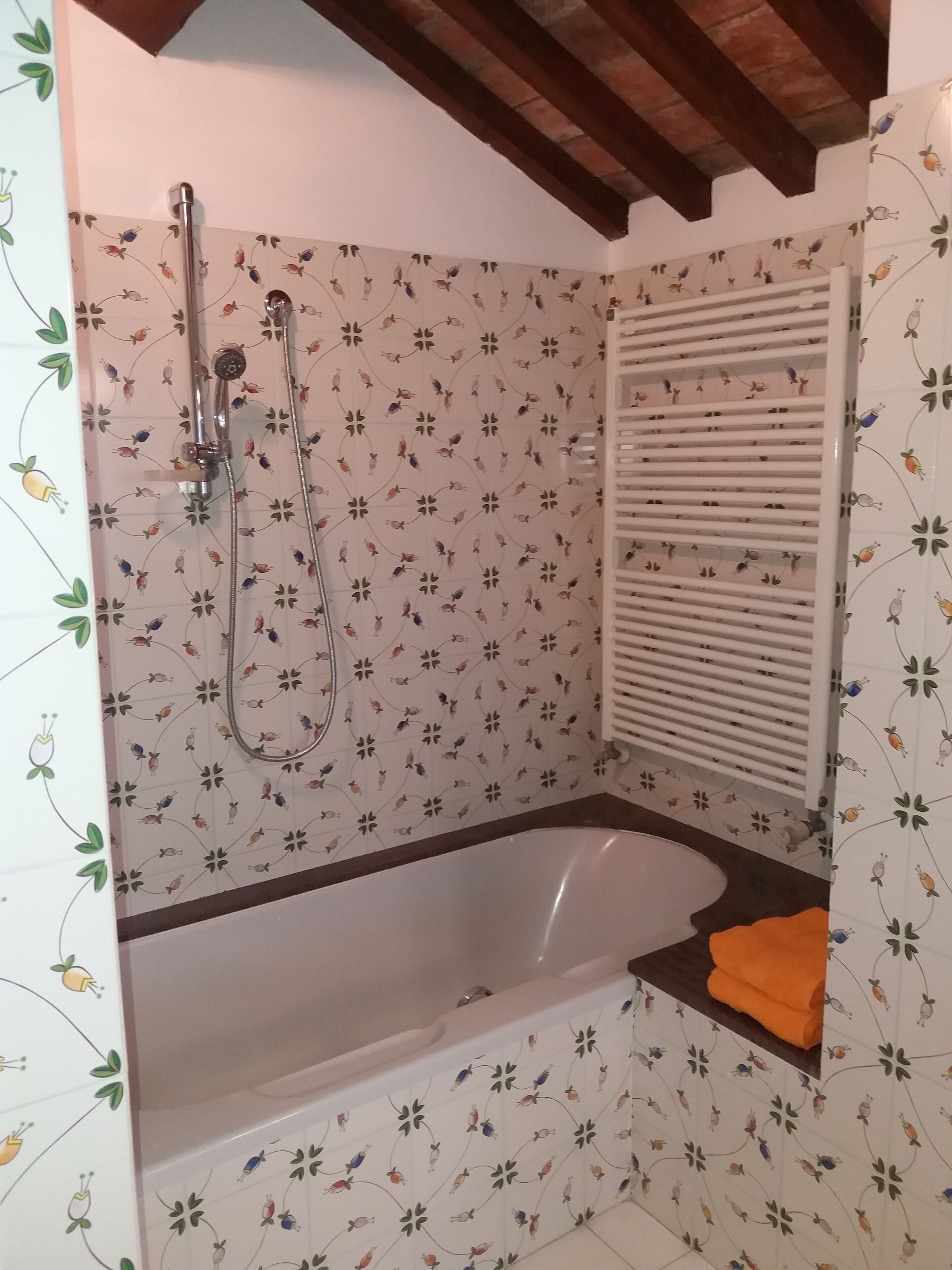 Un baño con ducha, bañera y ventana con persianas.