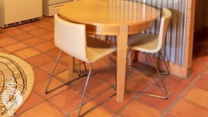A compact kitchen with a refrigerator, microwave, oven, and a round wooden table with two chairs. - Studio Apartment in Historic Neighborhood (Amarillo)