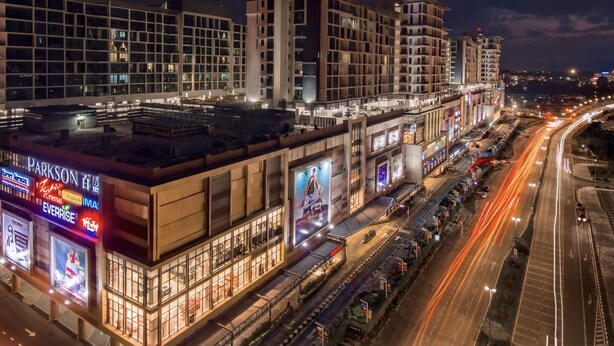 A multi-story hotel with a modern architectural design, featuring a prominent cinema and restaurant on the ground floor. - Luco Apartments Viva City Megamall (Kuching)