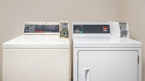 Deux machines à laver industrielles blanches, dotées de panneaux de commande.