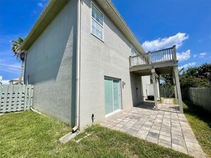Uma casa térrea com varanda coberta e um pequeno jardim frontal.