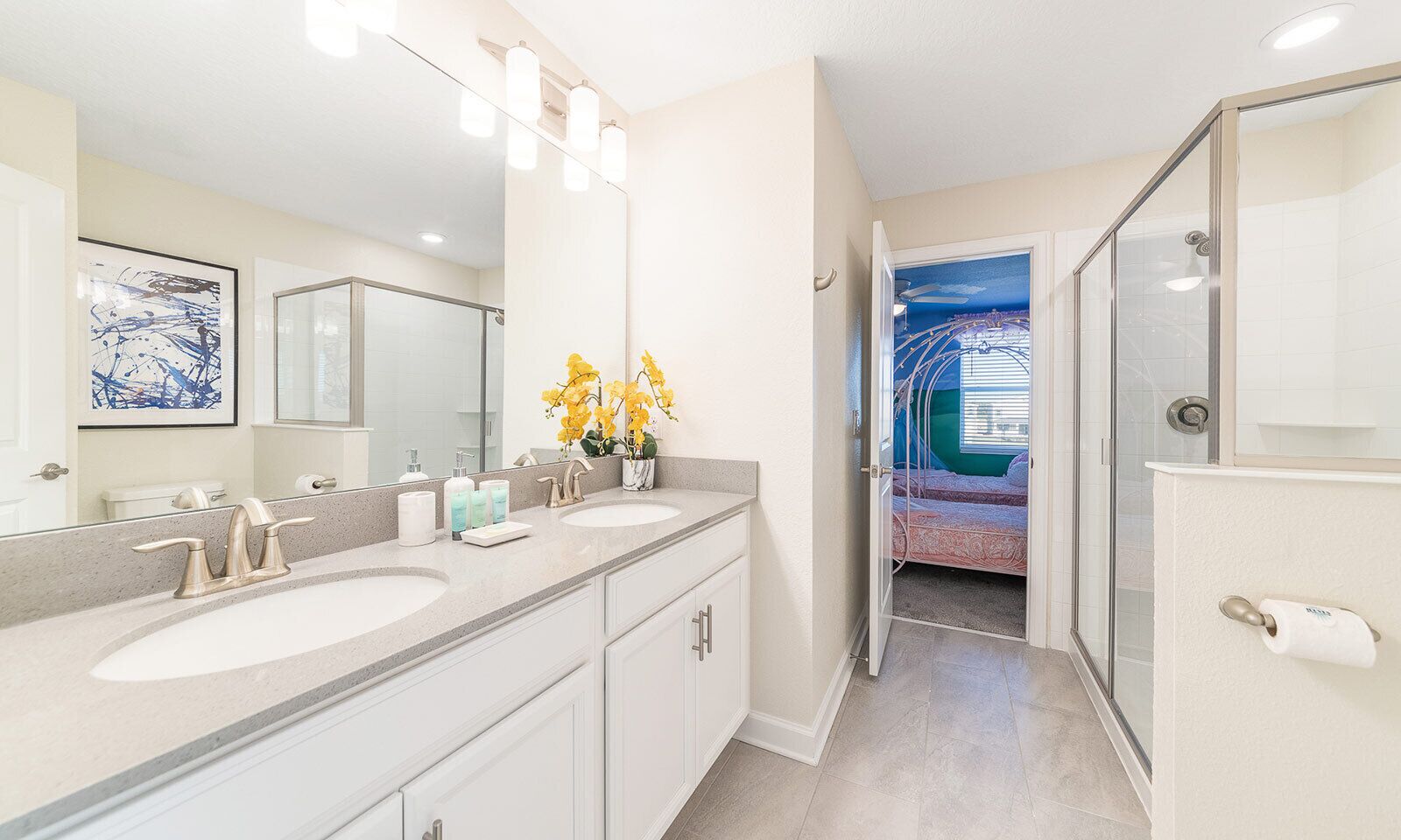 A modern bathroom with two sinks, a large mirror, and a shower area.