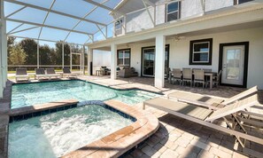 Ein Poolbereich mit Liegestühlen und einem Whirlpool.