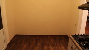 A kitchen with a wooden floor and a gas stove.
