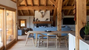 A wooden interior with a dining area, a fireplace, and a view of the outdoors. - B&B Chalet Nono (Montriond)