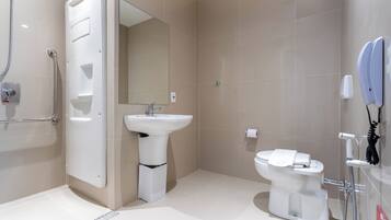A modern bathroom with a walk-in shower, a pedestal sink, a toilet, and a mirror.