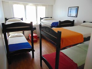 A dormitory room with four bunk beds, a window with curtains, and a framed picture on the wall. - Hostel Playa Grande (Mar del Plata)