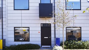 Un edificio moderno con múltiples ventanas y una puerta negra.