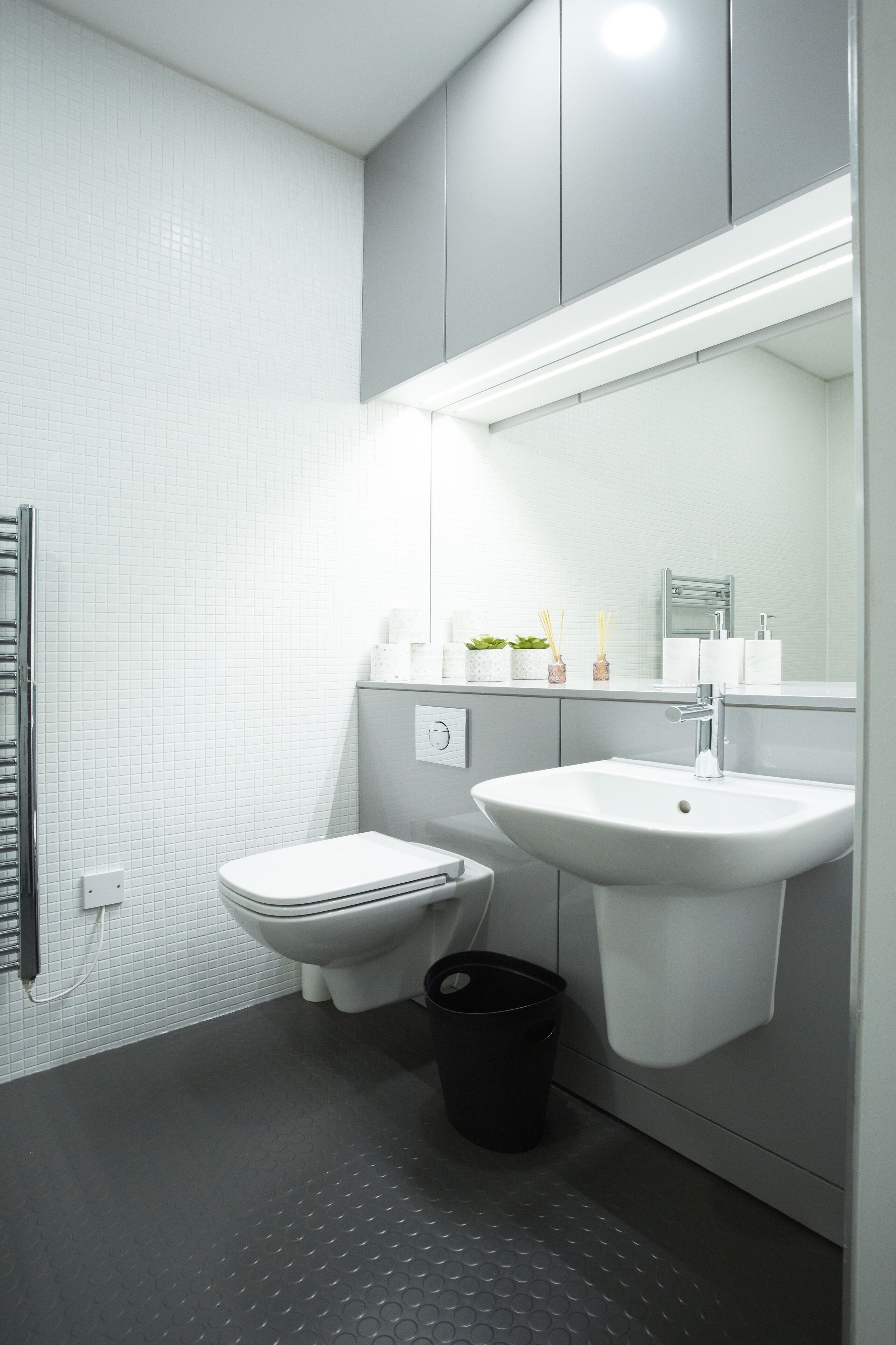 A modern bathroom with a toilet, sink, and a towel rack.